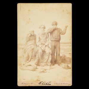 Aboriginal group, including a man wearing a king plate and a Queensland Native Police tracker aiming a rifle. Brisbane, circa 1885.